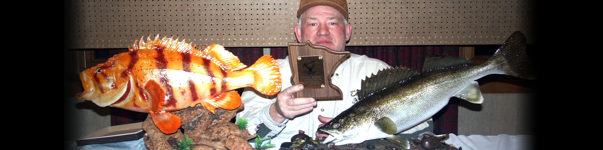 Licensed taxidermist, Mike Kahlert, pictured with awards for various fish mounts that he created